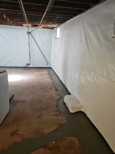 Completed interior drain tile system and vapor barrier installation for basement waterproofing in Rochester, MN.