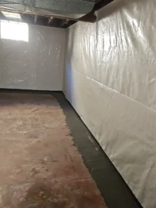 Completed interior drain tile system and vapor barrier installation for basement waterproofing in Rochester, MN.